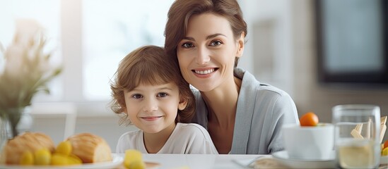Wall Mural - during breakfast a delightful image captures a smiling young mother and her adorable son looking int