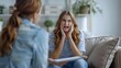 © HY - Anxious teenage girl in therapy session, expressing concern and holding her face, interacting with counselor