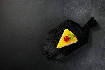 Wall Mural - Lemon cheesecake with cherry. On a black background