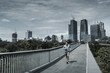 © Charnchai saeheng - A man running up on footbridge in the city center park for cardio workout.  Health and Lifestyle in big city life concept.