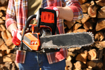 Wall Mural - Man with modern saw on sunny day, closeup