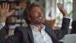 © QuietWord - middle age Caucasian business man carefree smiling happy  in joy with a laptop on his desk,