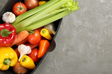 Wall Mural - Black pot with fresh vegetables on grey table, top view. Space for text