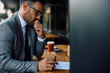 © Drazen - Thoughtful businessman going through paperwork while sitting in café.