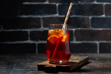 Wall Mural - glass of fresh iced tea with lemon on dark background