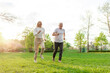 © Богдан Маліцький - elderly senior couple man and woman running and exercising in the park outdoors, gray-haired grandparents doing sports and active lifestyle in nature