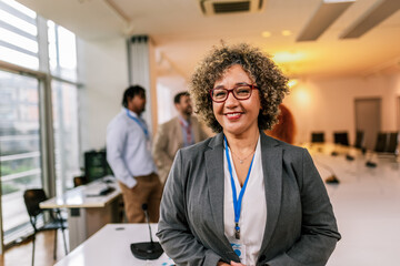 Portrait of older African American businesswoman standing in front of her colleagues.