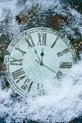 Wall Mural - New Years clock and fir branches covered with snow flakes, flat lay