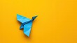 © pitu - blue origami airplane symbol with yellow background