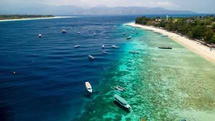 Wall Mural - Snorkelling and SCUBA tour boats on the reef edge next to the main beach of Gili Trawangan, Indonesia