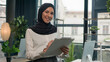 © Yuliia - Happy muslim Islam woman Arabian girl in hijab HR manager secretary with paper tablet write notes sign data in note tablet writing to-do list business ideas successful businesswoman planning workflow
