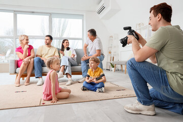 Canvas Print - Male photographer taking picture of family with little children in studio