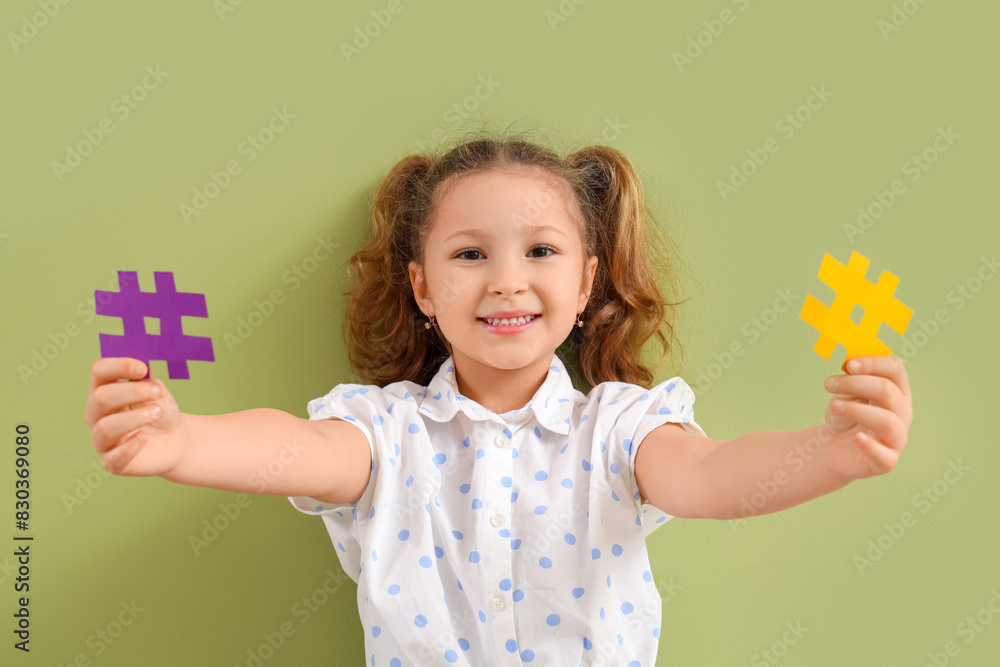 Cute little girl with hashtags on green background