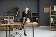 © Pixel-Shot - Attractive African-American secretary sitting on table in office