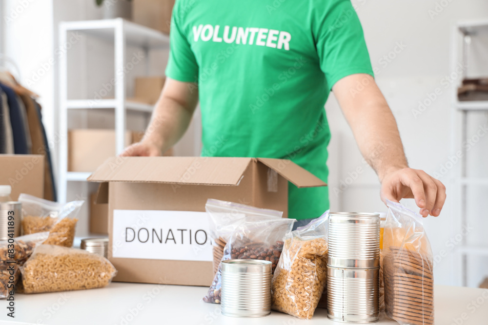Male volunteer donating food in center, closeup