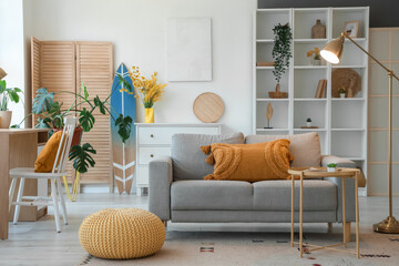 Sticker - Interior of living room with sofa, workplace and surfboard