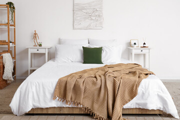 Poster - Interior of light bedroom with cozy bed and reed diffuser on bedside table