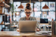 © Kartika - Focused young woman working on laptop in coffee shop