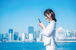 © maroke - 外でスマホを使う若いビジネスウーマン