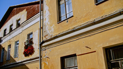 Wall Mural - Old residential building facade with scuffed plaster. Stock footage. Old apartment building on a sunny day.