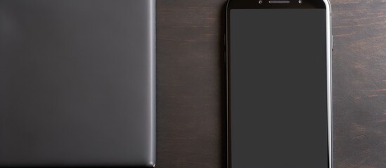 Poster - Top view of a Black smart phone and a black power bank being charged on a paper background with copy space image available