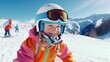 © vefimov - A young girl wearing a bright orange jacket and goggles is smiling as she rides a snowboard down a snowy slope