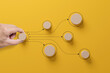 © Monster Ztudio - Business process and workflow automation with flowchart. Hand holding wooden cube block arranging processing management on yellow background