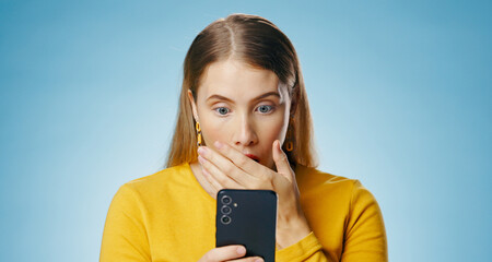 Poster - Woman, shocked and reading with smartphone in studio, blog update and message notification on networking app. Social media, communication and promo for news or gossip, blue background and online