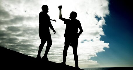 Poster - People, high five and fitness on rock at beach for helping hand, clouds and outdoor together. Men, support and lift for partnership, silhouette or low angle in training, exercise or workout in summer