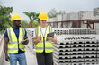 © chachamp - Portrait African engineer man use clipboard and Hispanic latin engineer woman use tablet computer checking precast cement at precast cement outdoor factory