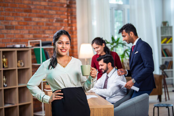 Wall Mural - Indian young businesspeople using laptop in group meeting at desk