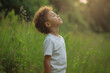 © Varitnan - a child takes deep breath fresh air in the field of meadow and forest, nature and environment generative Ai