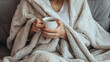 © Ruslan - Sick woman on the sofa wrapped in a blanket with a cup of tea