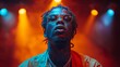 © familymedia - Close-up of a performer with dreadlocks, face censored, showcasing neck tattoos and colorful jacket under stage lights