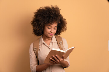 Wall Mural - focused college student studying with book in studio shot. learn, school, student life concept.