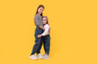 © New Africa - Full length portrait of cute little sisters on orange background, space for text