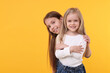 © New Africa - Portrait of cute little sisters on orange background, space for text