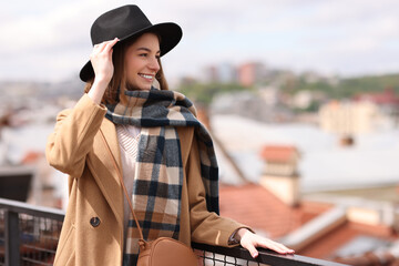 Poster - Beautiful woman in warm scarf and hat outdoors, space for text