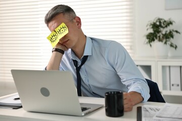 Wall Mural - Man with fake eyes painted on sticky notes snoozing at workplace in office