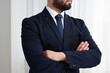 © New Africa - Businessman in suit and necktie with crossed arms indoors, closeup