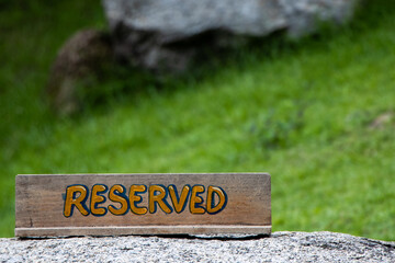 Selective focus wooden signs with the text reserved On rocks, lawns, and public areas