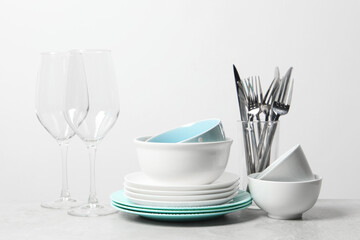 Wall Mural - Beautiful ceramic dishware, glasses and cutlery on light grey table