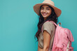 © Niks Ads - young indian woman standing with backpack on blue background