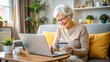 © Pornchai - Elderly woman using laptop for online shopping at home