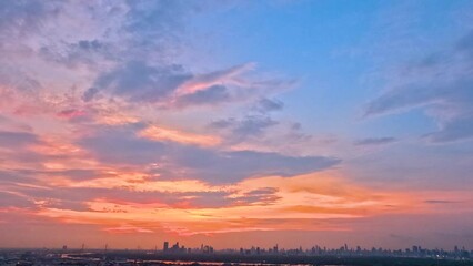 Wall Mural - Time lapse interval sunset over modern office buildings in business district. Skyline cirrus cloudscape view of cityscape with disc sun sunlight and flare.