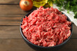 © New Africa - Raw ground meat in bowl on wooden table, closeup
