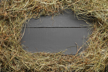 Poster - Frame made of dried hay on grey wooden table, top view. Space for text