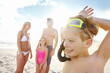 © Grady Reese/peopleimages.com - Happy, family and kids with goggles relax on beach for snorkeling, adventure and happiness on vacation. Child, smile and parents with girl on holiday in Florida, summer or excited for swimming in sea