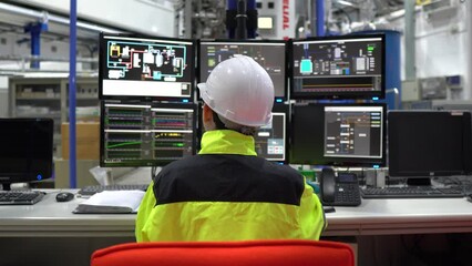 computer engineer working in a large industrial factory, using programming software to control machi