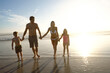 © Grady Reese/peopleimages.com - Sunset, love and family holding hands at a beach for summer, fun and bonding in nature together. Travel, people and children with parents at sea for vacation, journey or tropical adventure in Florida